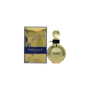 Rochas Byzance Gold Eau De Parfum 60 ml – rund guldfarvet flakon med riflet glas, smal talje og dekorativ gylden hætte